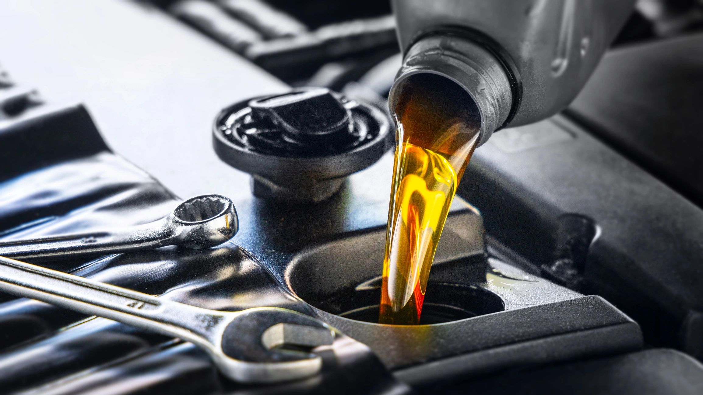 Pouring motor oil into an engine during an oil change