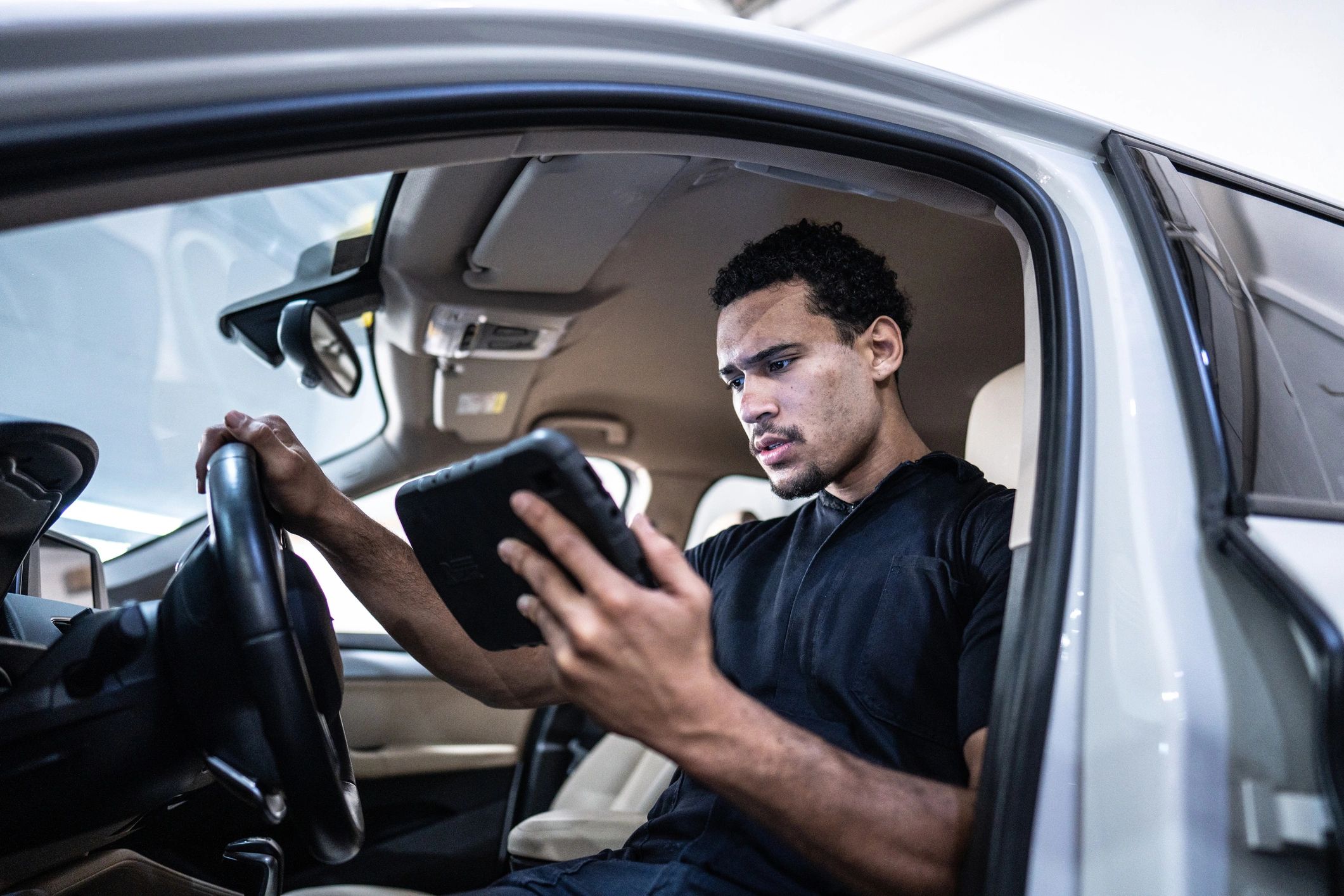 Mechanic using a tablet to diagnose a vehicle in the shop