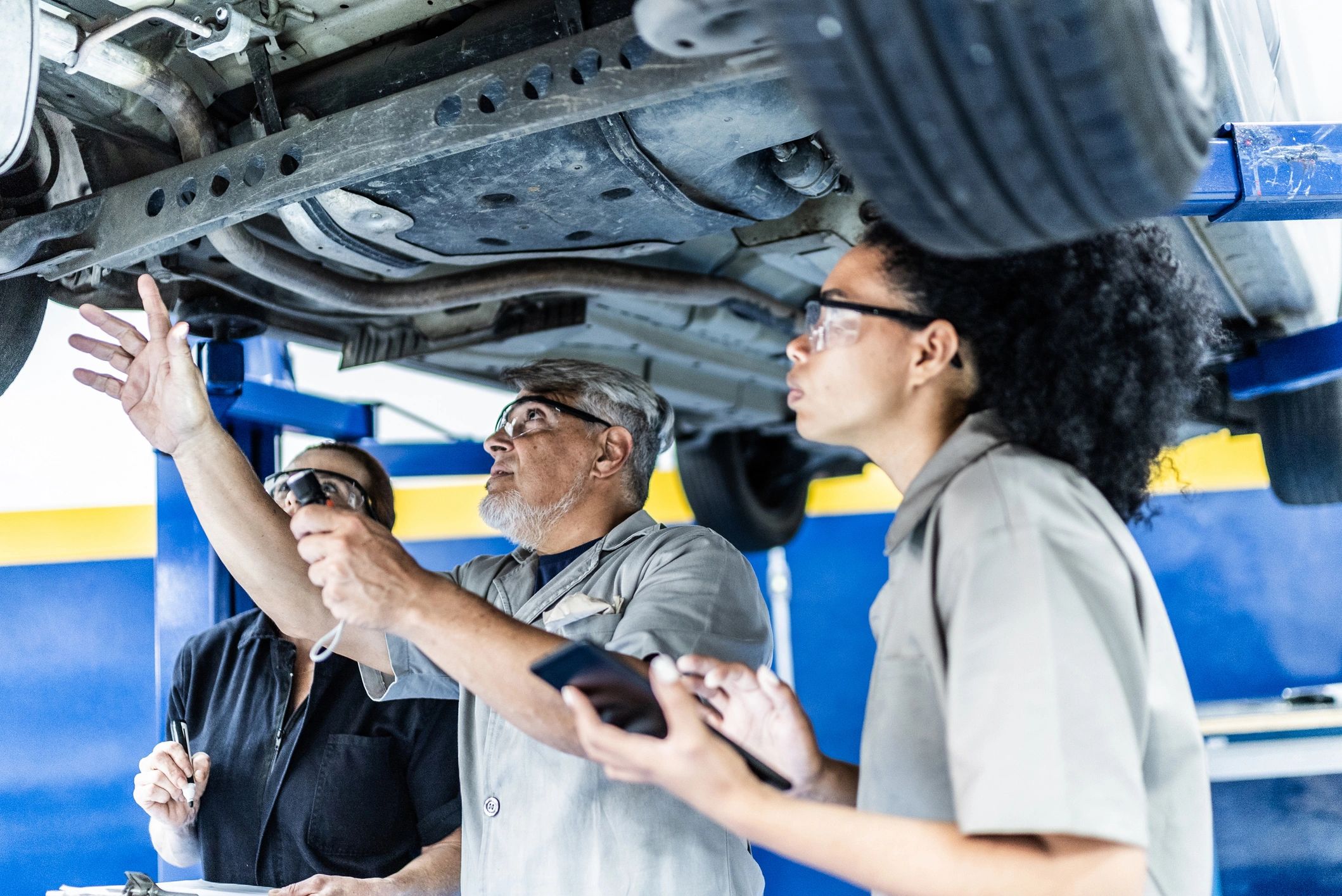 Technicians performing service on a vehicle