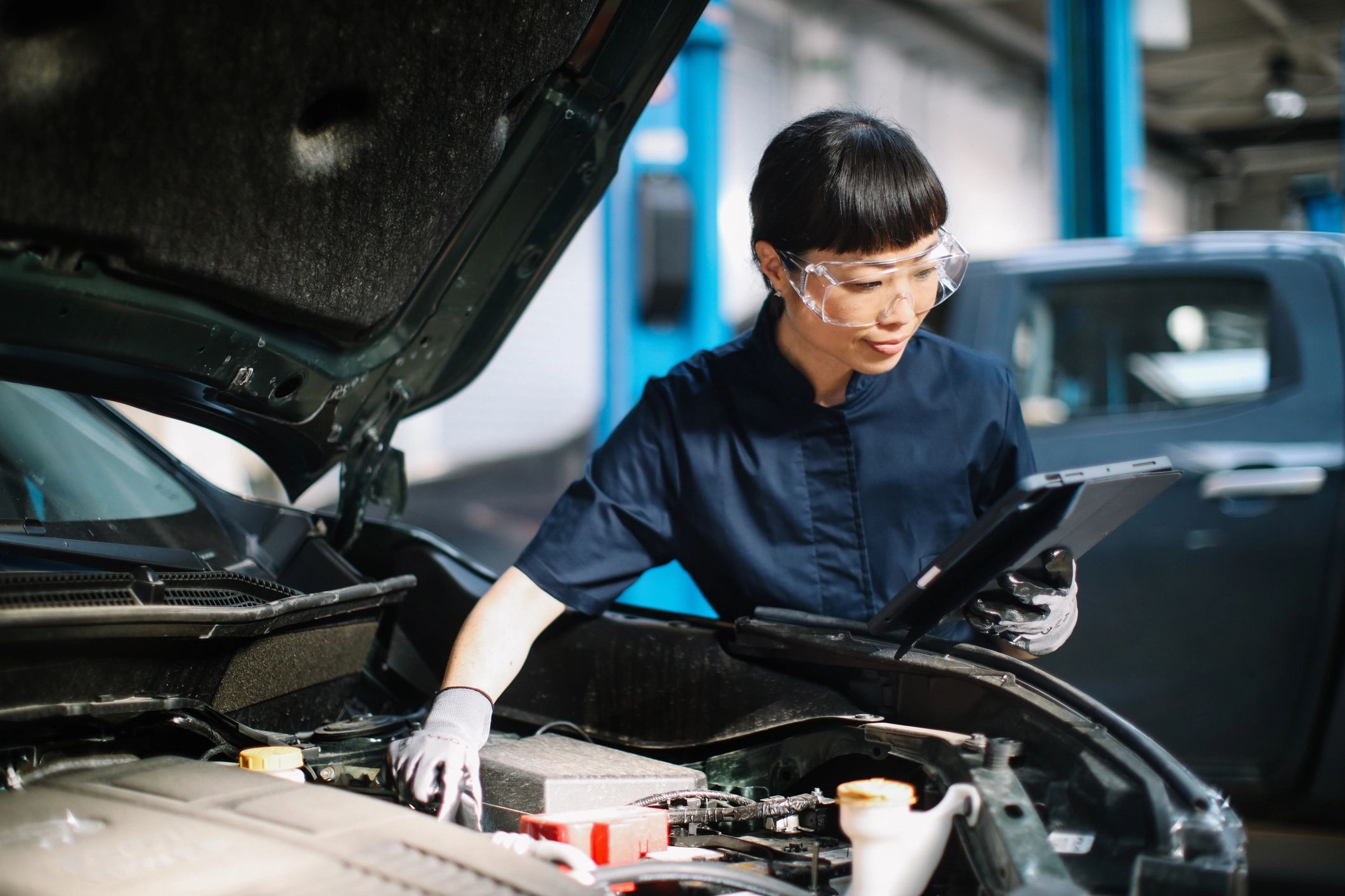 Technician performing a vehicle inspection in a clean repair shop