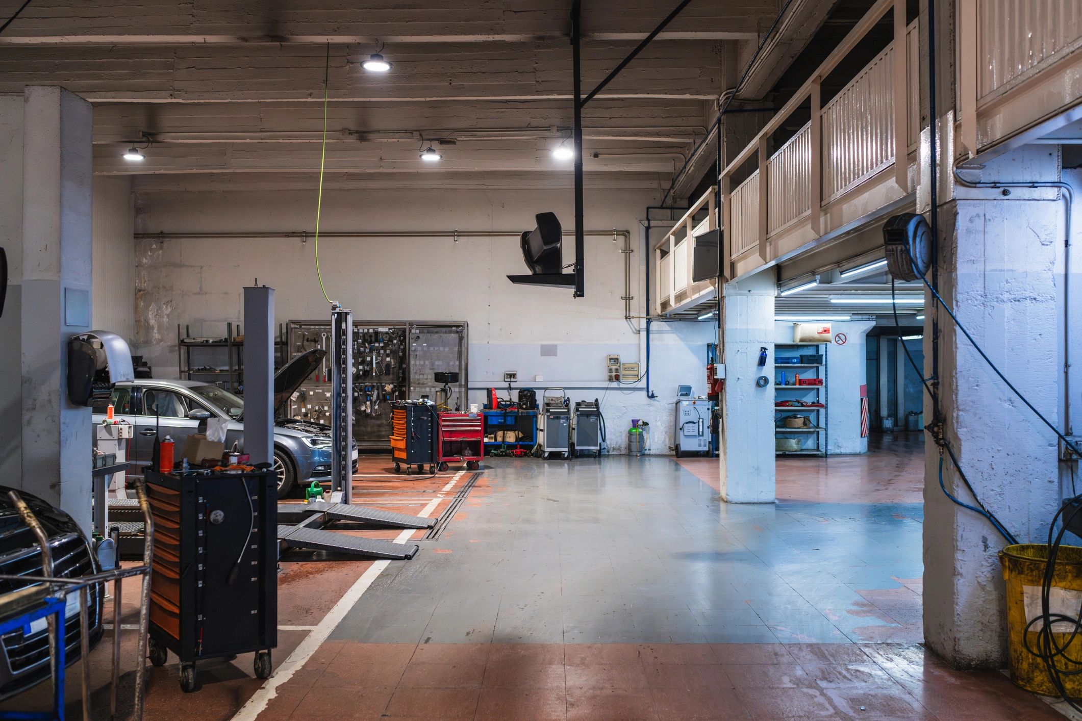 Auto repair shop bay with vehicle lifts and toolboxes