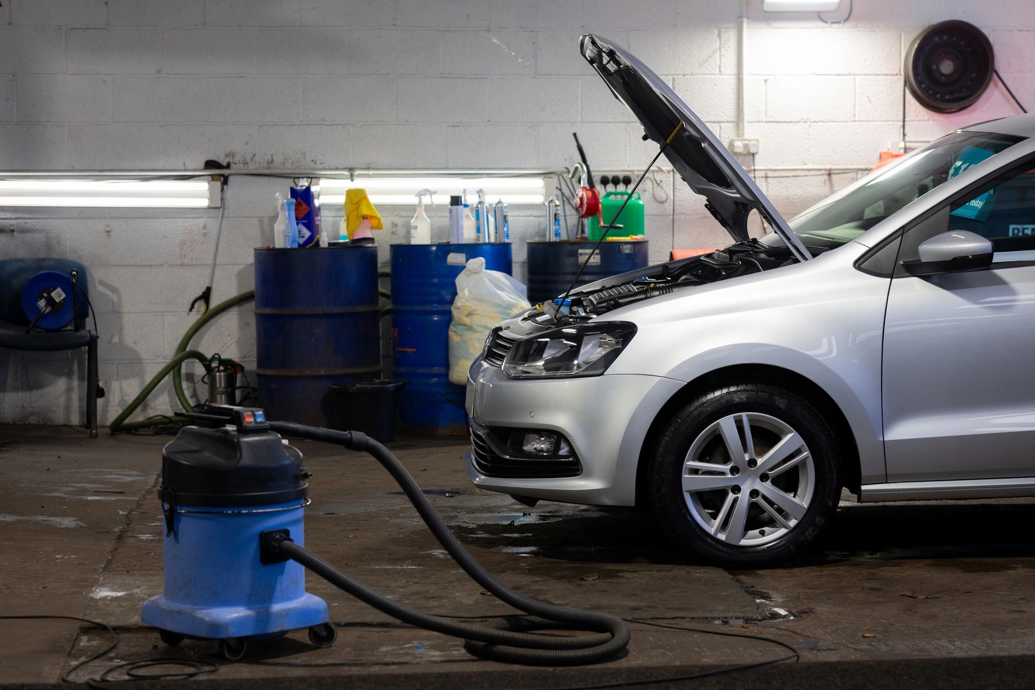 Vehicle being serviced in a garage with hood open