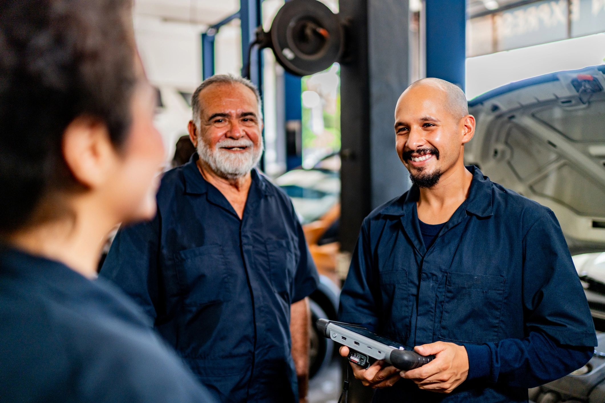 Mechanics discussing a repair plan in the shop