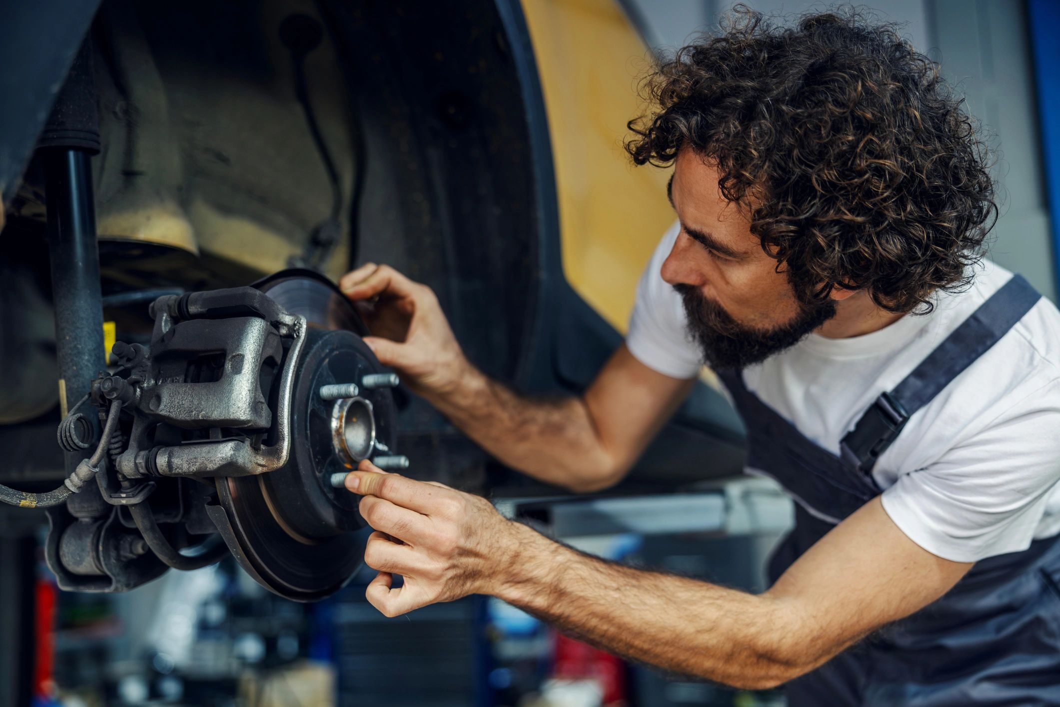 Mechanic servicing a car brake system in a garage